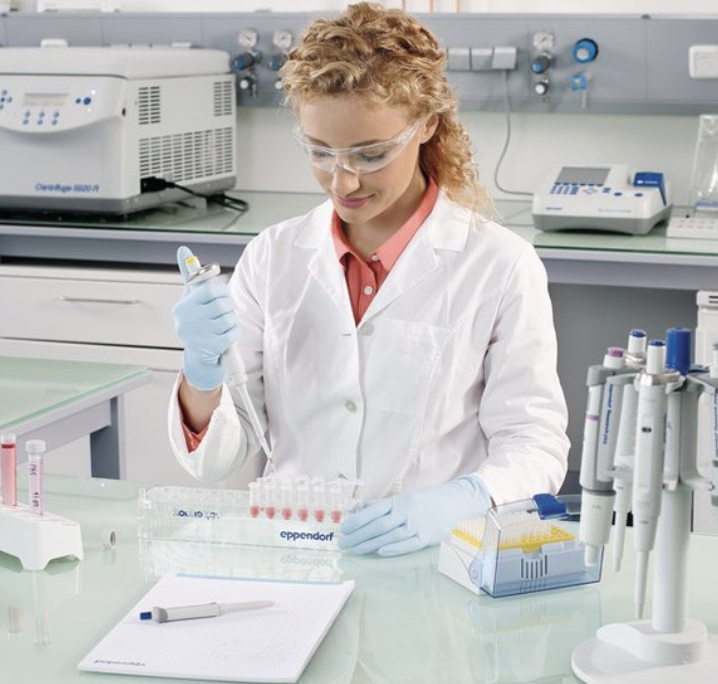 Scientist manually pipetting samples at a laboratory bench